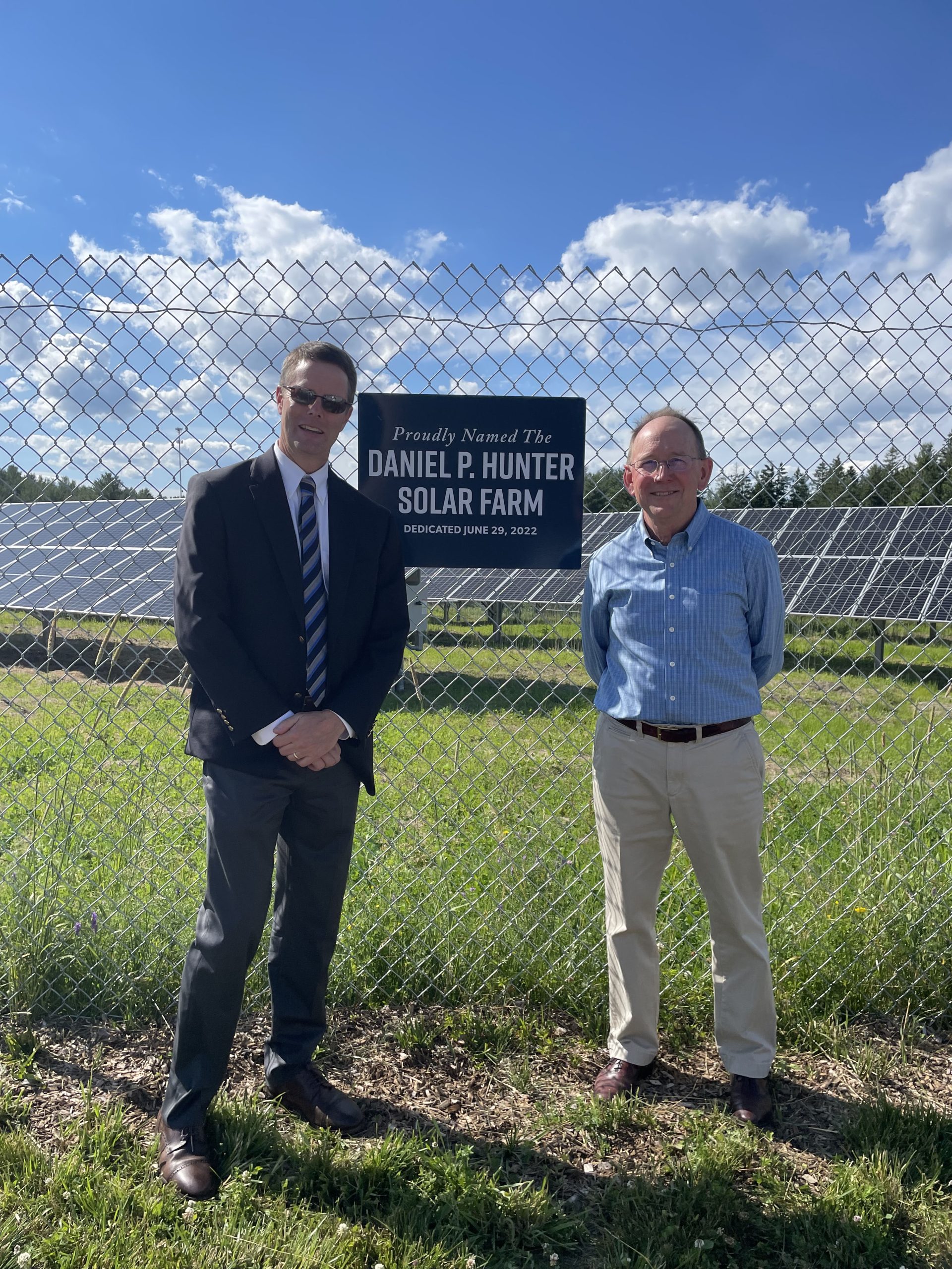 Steve deCastro and Dan Hunter standing in front of Daniel P Hunter solar farm at GSB operations center