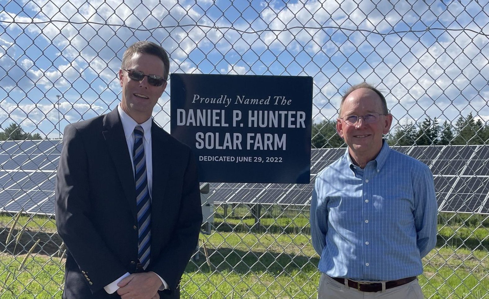 Steve deCastro and Dan Hunter standing in front of Daniel P Hunter solar farm at GSB operations center